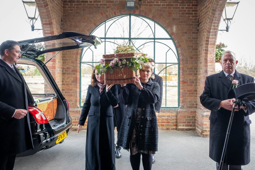 funeral directors carrying a coffin